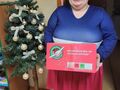 Dziewczynka uśmiecha się i trzyma prezent w tle choinkajpg