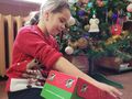 dziewczynka otwiera prezent w tle choinka