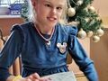 dziewczynka trzyma prezent w tle choinka