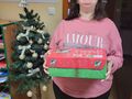 uśmiechnięta dziewczynka trzyma prezent w tle choinka