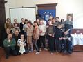 uczniowie klas starszych szkoły podstawowej razem z nauczycielami, ojcem Walentym i figurą Matki Bożej Fatimskiej pozują, większość stoi, niektórzy klęczą