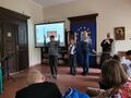 uczniowie tańczą z ojcem Walentym, który trzyma mikrofon, obok na biurku z białym obrusem stoi figura Maryi, na ścianie wisi obraz Matki Boskiej Częstochowskiej, z lewej strony wyświetlana prezentacja rekolekcyjna z napisem Maryja w koronie, u dołu i z prawej strony siedzą uczniowie i nauczyciele