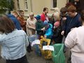 Grupa uczniów znajduje się przed budynkiem szkoły. Uczniowie mają założone rękawiczki trzymają worki ze śmieciami segregują je do worków odpow