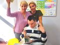 Uczeń Jakub w towarzystwie nauczycielek składających mu życzenia urodzinowe