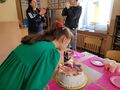 2. Dziewczynka dmucha świeczki na torcie 