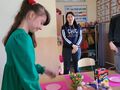 3. Dziewczynka uśmiecha się obok stoi opiekunka 