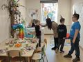 Śpiewanie sto lat, chłopcy i nauczycielka stoją w klasie, uśmiechają się, pani składa życzenia Michałowi
