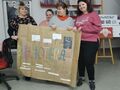 3. Prezentacja plakatu biblioterapia - uczniowie i nauczycielka trzymają plakat z napisem bibliotekoterapia