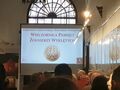 Widownia siedzi na krzesłach projektor wyświetla napis Narodowy Dzień Pamięci Żołnierzy Wyklętych Wieczornica Pamięci Żołnierzy Wyklętych