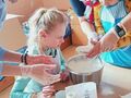 8. Uczniowie przy wsparciu opiekunów dodają mąkę do ciasta 