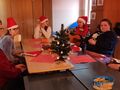 Zdjęcie nr 3. Harcerze siedzą przy stole i śpiewają kolędy 2