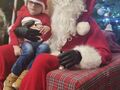 święty mikołaj z chłopcem siedzi na fotelu