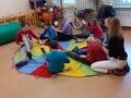 6. Dzieci siedzą na chuście jeden za drugim i robią masaż 