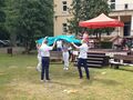 13 grupa taneczna wykonuje wystep trzymają skrzyżowane niebieskie płachty w rękach