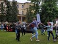 grupa taneczna uczniów oraz nauczycieli tańczy w kole