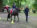 zawodniczka jedzie na koniu konia prowadzi hipoterapeutka