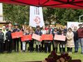 zdjęcie grupowe wszyscy stoją na tle flagi olimpiad specjalnych