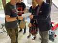Naczelnik Wydziału Edukacji Kultury i Sportu wręcza dyplom zawodnikowi obok stoi Pani Dyrektor