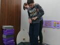 uczeń z pomocą nauczyciela skacze na trampolinie