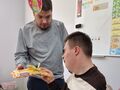 Filip kolega z klasy Jakuba wręcza mu czekoladę urodzinową