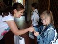 7. Nauczycielka wręcza dziewczynce nagrodę 