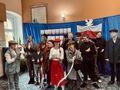 grupa uczniów i nauczycieli przebranych w stylu przedwojennej Polski śpiewa piosenkę