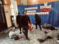 występ grupy teratralnej w holu szkoły czesc osob lezy na podłodze reszta ubranych na czarno chodzi wokół nich ubranych na czarno