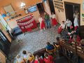 Na zdjęciu możemy zobaczyć napis Święto Konstytucji 3 Maja oraz harcerza trzymajacego flagę. Obok chłopca stoją 2 dziewczynki 