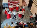 Zdjęcie przedstawia uczniów nauczycieli którzy znajdują się w szkolnym holu. Zobaczyć możemy tańczące dzieci oraz panie 