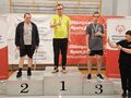 zawodnicy stoją na podium obok stoi pani wszyscy pokazują kciukiem gest ok