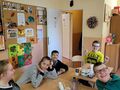 1. Uczniowie siedzą przy stole na którym są produkty i sprzęty potrzebne do zajęć kulinarnych 