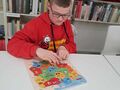 3. Wychowanek układa puzzle mapę Polski 