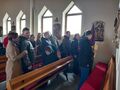 3.uczniowie stoją przy jednej ze stacji drogi krzyżowej w kościele