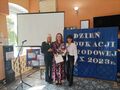 Nauczyciel stoi w holu wraz z dyrektorem i wicedyrektorem