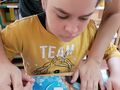 4. Uczennica z pomocą nauczyciela tworzy upominek dla rodziców 