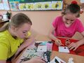7. Uczennice malują drewniane kwiaty 