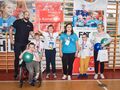 7 Dzieci wraz ze swoimi trenerami pozują do zdjęcia po zakończonych zawodach