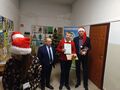 chłopiec trzyma w rece dyplom i nagrody stoi obok starosty