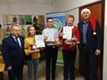 organizatorzy i laureaci konkursu stoją z dyplomami i nagrodami