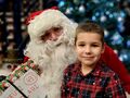28 chłopiec siedzi obok mikołaja w tle choinka