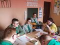 uczniowie śpiewają pieśni harcerskie przy akompaniamencie gitary