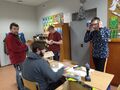uczniowie stoją w klasie przygotowują sprzet potrzebny do budowy karmnika dla ptaków