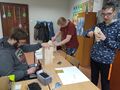 uczniowie w klasie przy ławkach szlifują za pomocą papieru ściernego drewno które posłuży do zbudowania karmnika dla ptaków