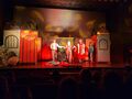 Zdjęcie 5 Scena podczas występu aktorzy ubrani na czerwono występują na scenie