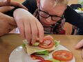 3. Uczeń z pomocą nauczyciela nakłada warzywa na kanapkę 