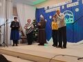12. jury i organizatorzy konkursu stoją na sceniez tyłu na granatowym tle szopka betlejemska i napis XV Międzyszkolny Konkurs Kolęd Pastorałek
