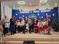 21.najmłodsi uczestnicy konkursu podczas wręczania nagródz tyłu na granatowym tle napis XV Międzyszkolny Konkurs Kolęd Pastorałek i Pieśni Zim