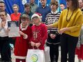 3. młodsi laureaci konkursu stoją na sceniepozują do zdjęcia po wręczeniu nagród z tyłu na granatowym tle napis XV Międzyszkolny Konkurs Kolę