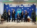 6.najstarsi uczestnicy konkursu podczas występu z tyłu na granatowym tle szopka betlejemska oraz napis XV Międzyszkolny Konkurs Kolęd Pastorał
