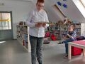 Na zdjęciu widzimy dwóch uczniów którzy są w bibliotece. Jeden z nich trzyma książkę 
